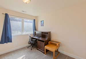 Office space with light colored carpet and baseboards