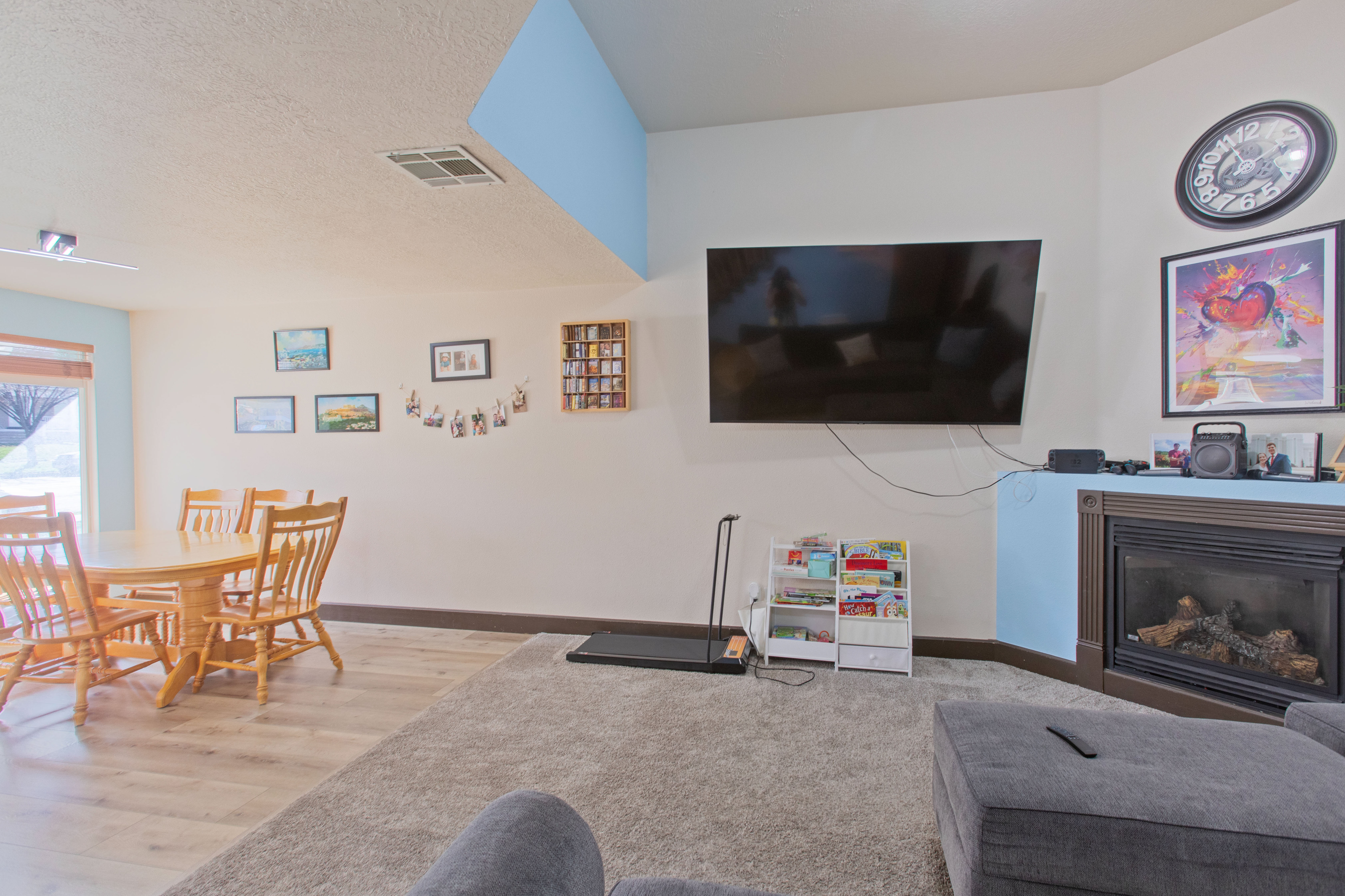 Living room with a glass covered fireplace, a textured ceiling, and wood finished floors