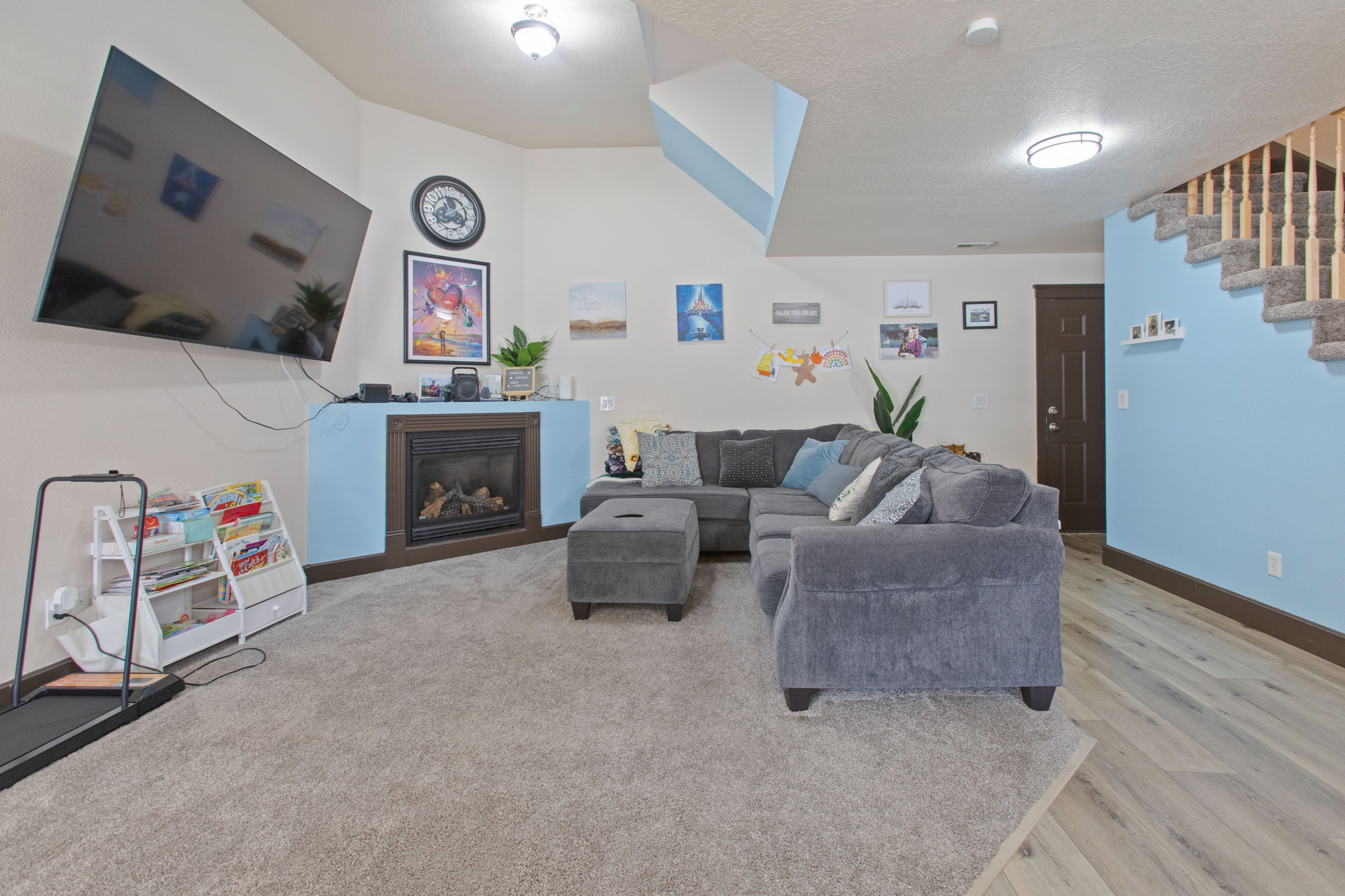 Living room with a glass covered fireplace, a textured ceiling, and light wood finished floors