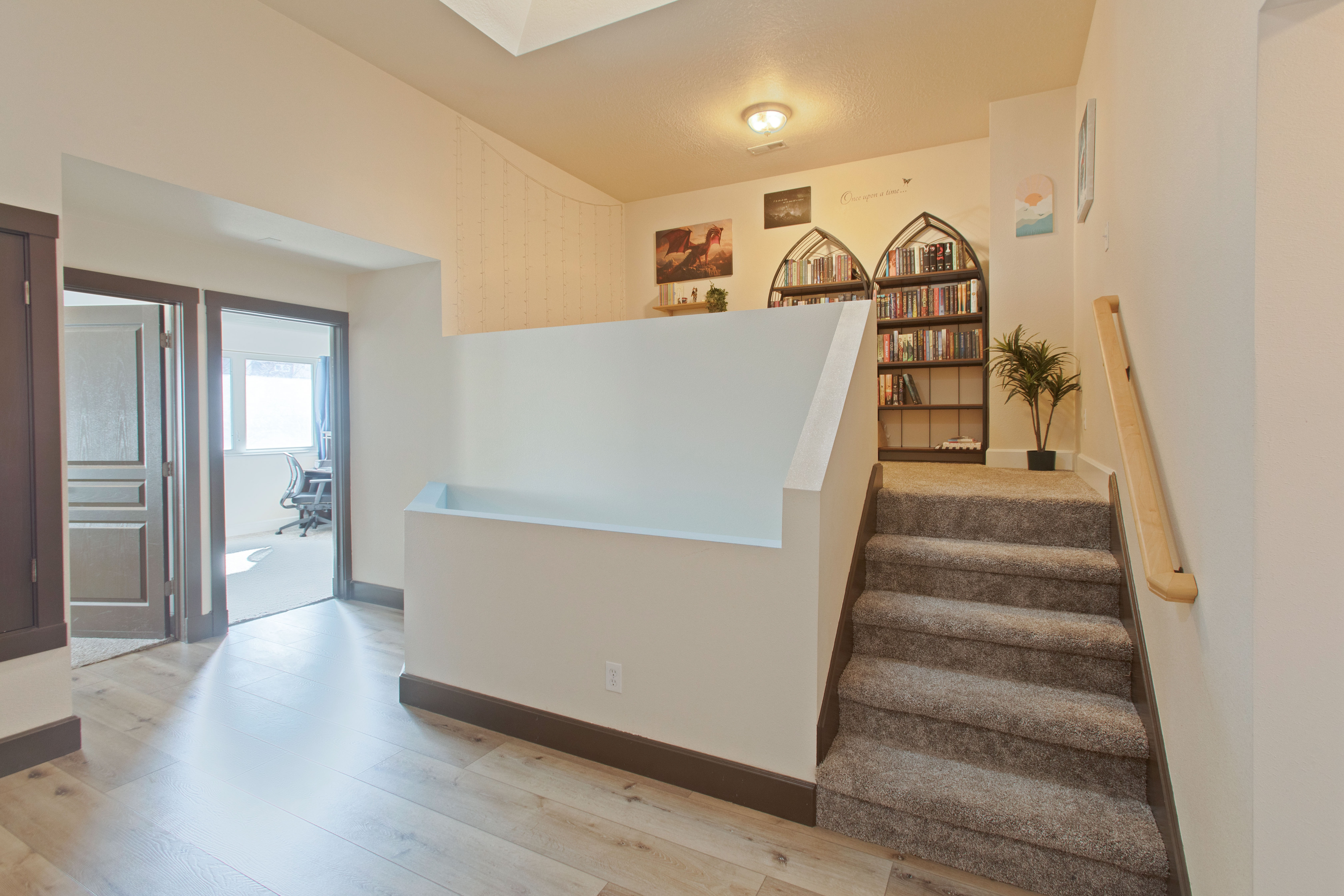 Stairway featuring wood finished floors and a skylight