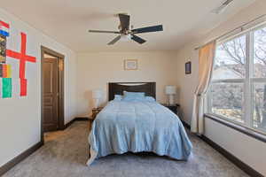Bedroom featuring a ceiling fan and carpet