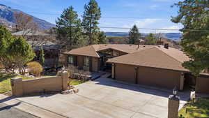 View of front of home featuring a shingled roof, concrete driveway, a garage, and a mountain view