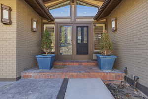 Doorway to property featuring brick siding and french doors