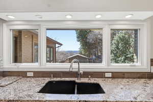 Kitchen with light stone countertops and a sink