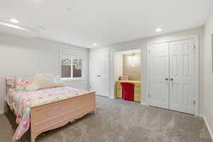 Bedroom featuring two closets, light carpet, and recessed lighting
