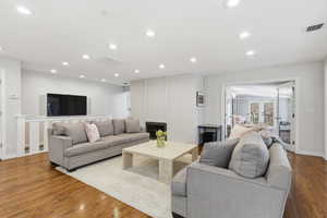 Living area with wood finished floors, french doors, recessed lighting, and a fireplace