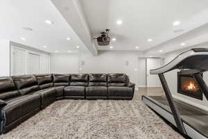 Cinema room featuring recessed lighting, a glass covered fireplace, and light wood-style flooring