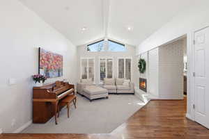 Living area featuring wood finished floors, a brick fireplace, and recessed lighting