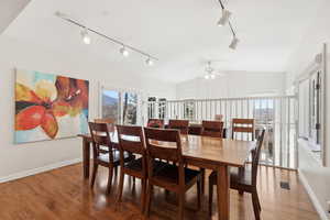 Dining area with track lighting, ceiling fan, lofted ceiling, and wood finished floors