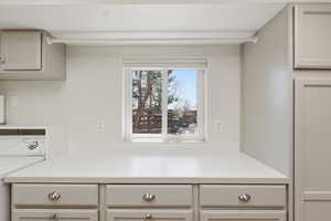 Kitchen with washer / clothes dryer, light countertops, and cream cabinets