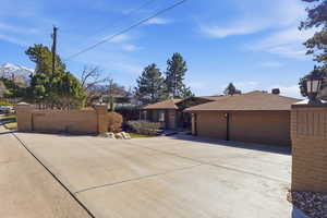 View of front of property featuring concrete driveway, a garage, and a shingled roof