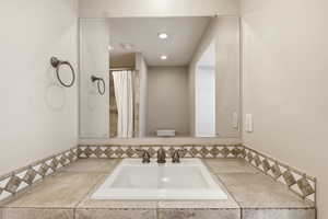 Bathroom with vanity, curtained shower, and recessed lighting