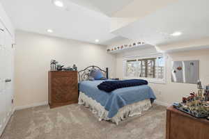 Bedroom with light carpet, recessed lighting, and a closet