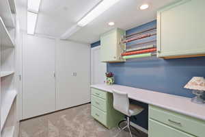 Office area with light colored carpet, recessed lighting, and built in desk