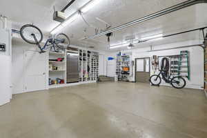 Garage featuring freestanding refrigerator and a garage door opener
