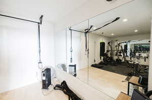 Exercise room featuring light wood-type flooring and recessed lighting