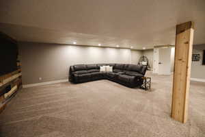 Living area with light colored carpet, a textured ceiling, and recessed lighting