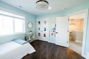 Bedroom with dark wood-style flooring and a closet