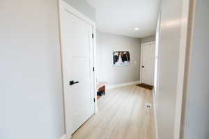 Corridor featuring light wood-style floors and recessed lighting