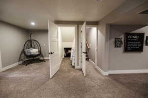 Finished below grade area with light colored carpet, a textured ceiling, and recessed lighting