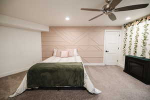 Carpeted bedroom with ceiling fan, recessed lighting, and an accent wall