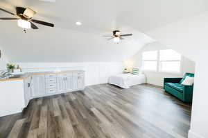 Unfurnished bedroom featuring ceiling fan, dark wood finished floors, lofted ceiling, and recessed lighting