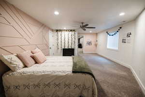 Carpeted bedroom featuring recessed lighting, ceiling fan, and an accent wall