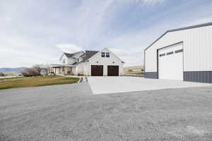 View of front of house featuring a porch, a detached garage, a front lawn, and concrete driveway