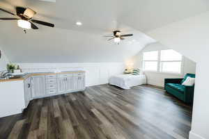 Unfurnished bedroom with dark wood-style floors, a ceiling fan, vaulted ceiling, and recessed lighting