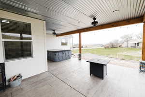 View of patio with a hot tub and ceiling fan
