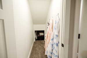 Hall with dark colored carpet and baseboards