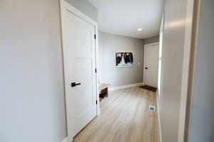 Hall with light wood-type flooring and recessed lighting