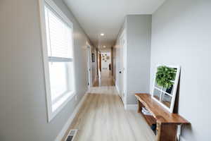 Hallway featuring light wood-type flooring and recessed lighting