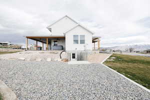View of front of home featuring a mountain view, a patio area, a ceiling fan, and a front lawn
