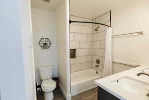 Bathroom with double vanity, shower / bath combo, and dark tile patterned floors