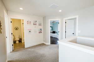 Hall featuring light carpet and recessed lighting