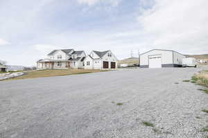 Modern inspired farmhouse featuring a detached garage, driveway, an outdoor structure, and a front lawn