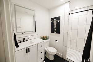 Full bathroom featuring a stall shower, vanity, dark tile patterned flooring, and recessed lighting