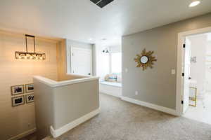 Hallway featuring light carpet, recessed lighting, and an upstairs landing