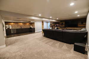 Living area featuring an accent wall, wet bar, recessed lighting, light carpet, and wine cooler