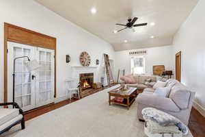 Living area featuring wood finished floors, ceiling fan, a brick fireplace, ornamental molding, and recessed lighting