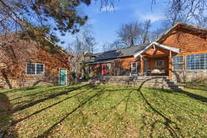 Rear view of house featuring a lawn and a patio