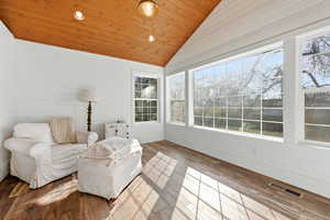 Sunroom / solarium featuring recessed lighting, hardwood / wood-style floors, wooden walls, and a vaulted wooden ceiling