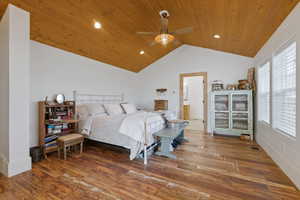Bedroom with dark wood finished floors, ceiling fan, recessed lighting, wooden ceiling, and ensuite bath