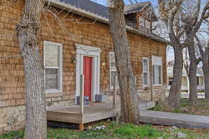 Doorway to property with roof with shingles