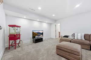 Living area featuring light colored carpet and recessed lighting