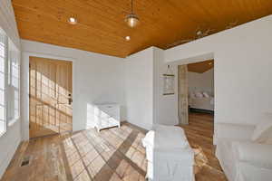 Living room with wood-type flooring, a vaulted wooden ceiling, and recessed lighting