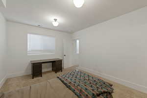 Bedroom with light carpet and baseboards
