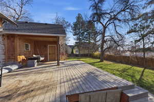 Wooden deck with a fenced backyard and a patio area