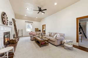 Living area with a glass covered fireplace, a ceiling fan, recessed lighting, and lofted ceiling